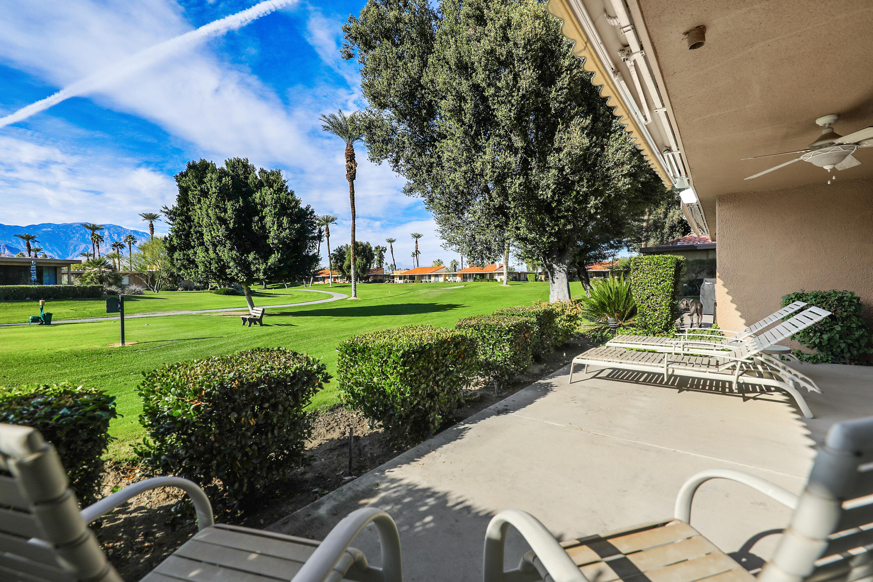 23 La Ronda Drive Rancho Mirage, CA 92270 - Photo 25 of 34 a view of a white house with a yard and furniture