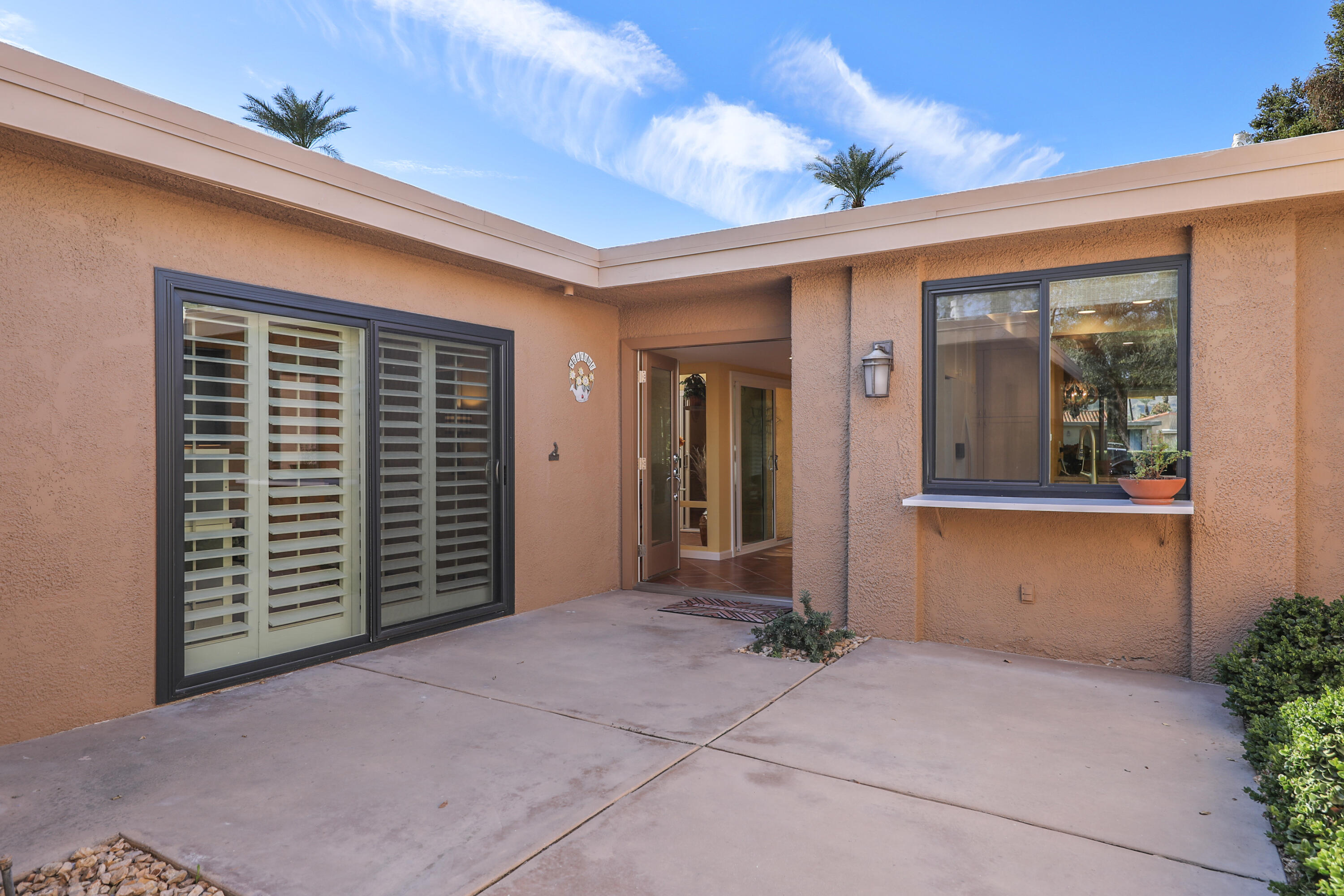 23 La Ronda Drive Rancho Mirage, CA 92270 - Photo 3 of 34 front view of a brick house with a large window