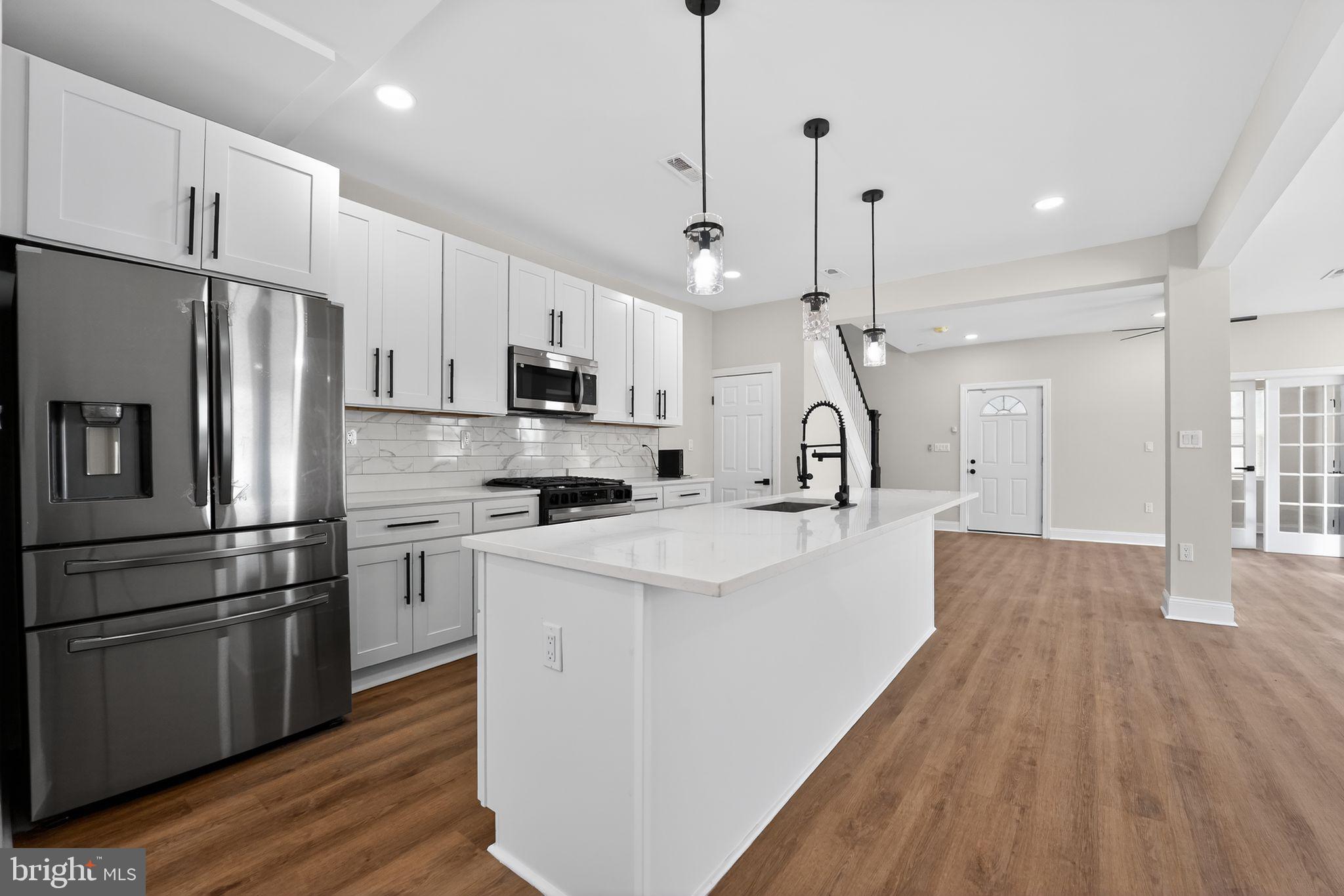 2911 Pinewood Avenue Baltimore, MD 21214 - Photo 1 of 30 a kitchen with kitchen island white cabinets and stainless steel appliances
