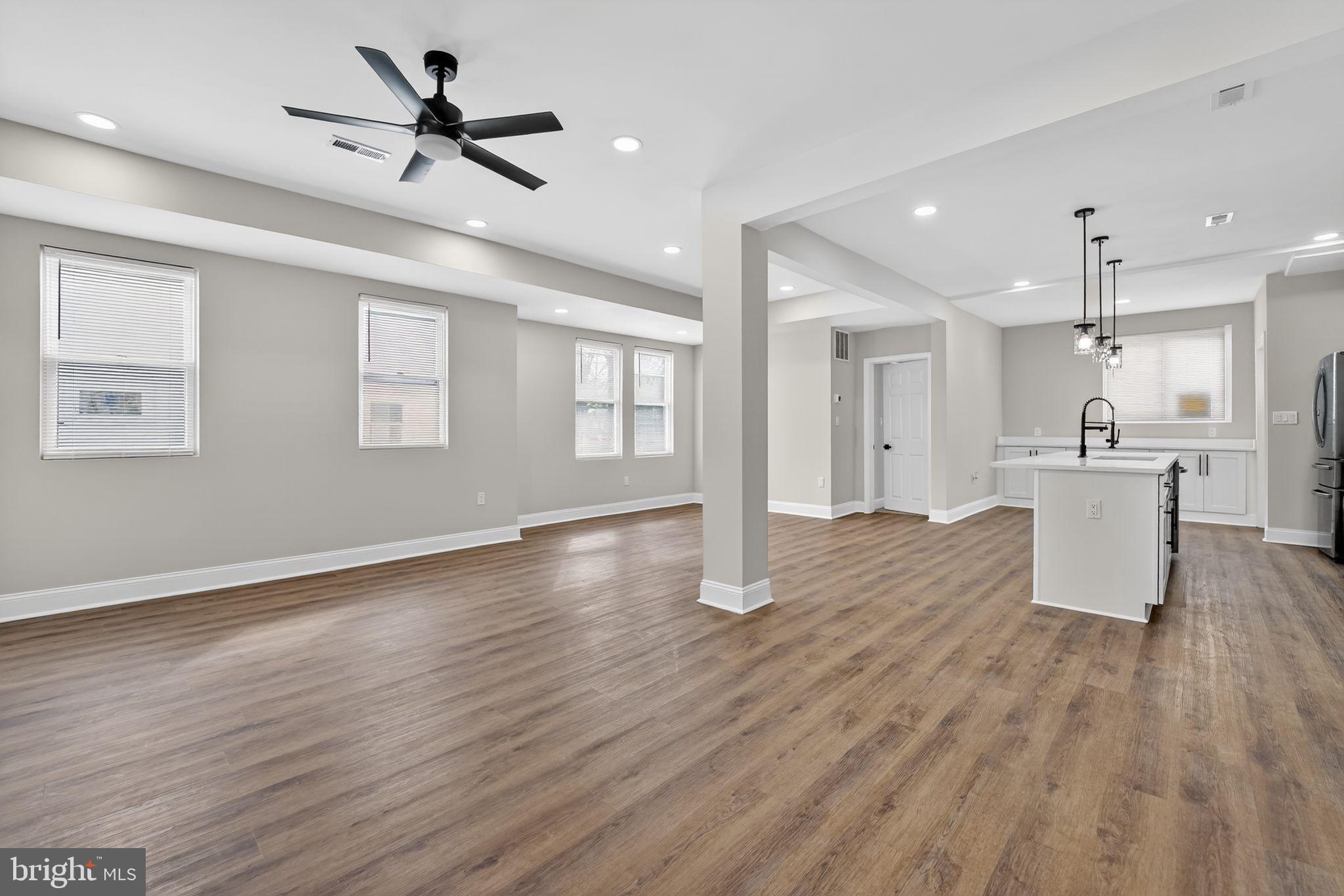 2911 Pinewood Avenue Baltimore, MD 21214 - Photo 3 of 30 a view of a kitchen with a kitchen island wooden floor appliances and a window