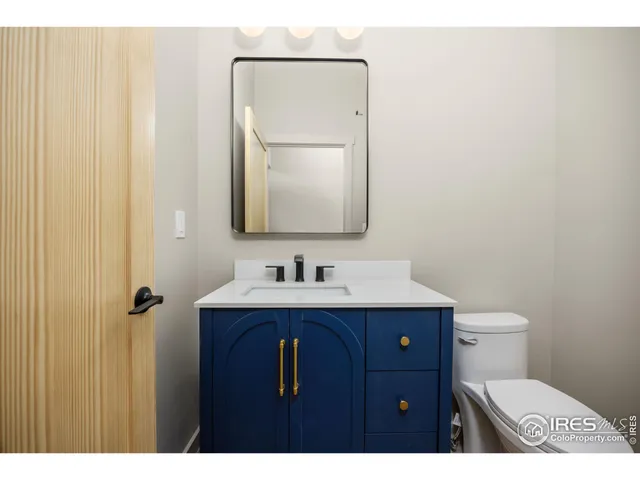a bathroom with a toilet a sink a vanity and mirror