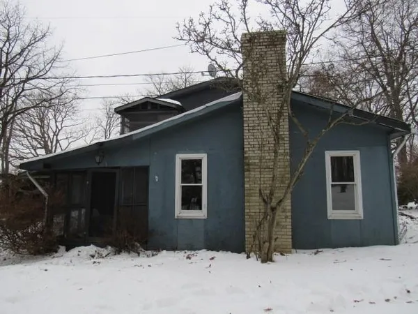 a view of house with yard and large tree