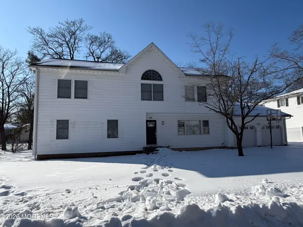 a view of a house with a yard covered in snow
