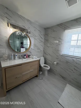 a bathroom with a double vanity sink mirror and toilet