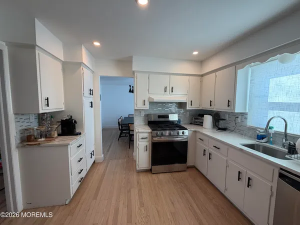a kitchen with stainless steel appliances a sink stove refrigerator and cabinets