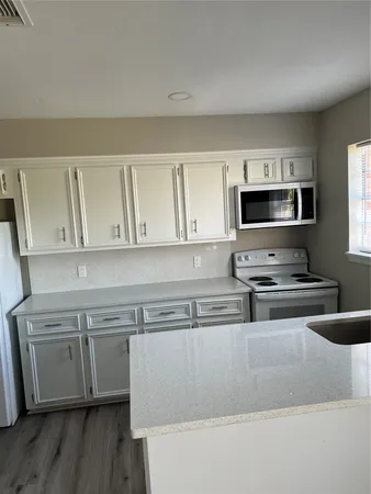 a kitchen with stainless steel appliances and white cabinets