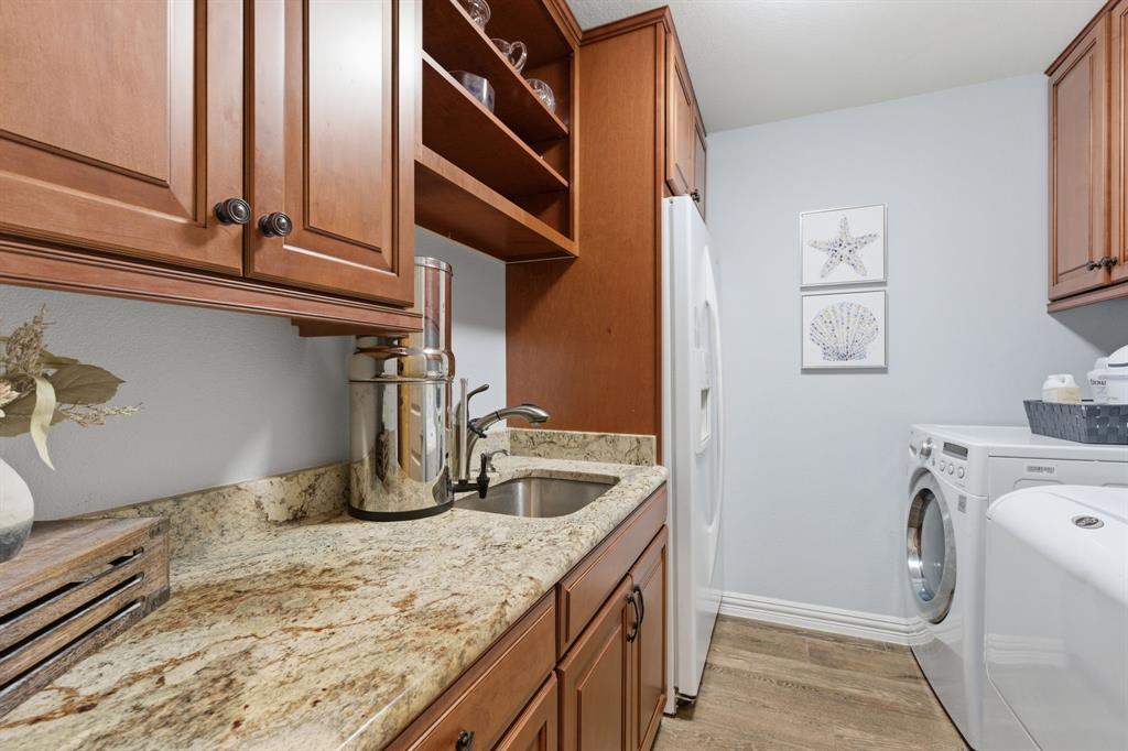 10390 Ridgecrest Street Frisco, TX 75033 - Photo 22 of 40 a kitchen with a granite countertop sink and washing machine