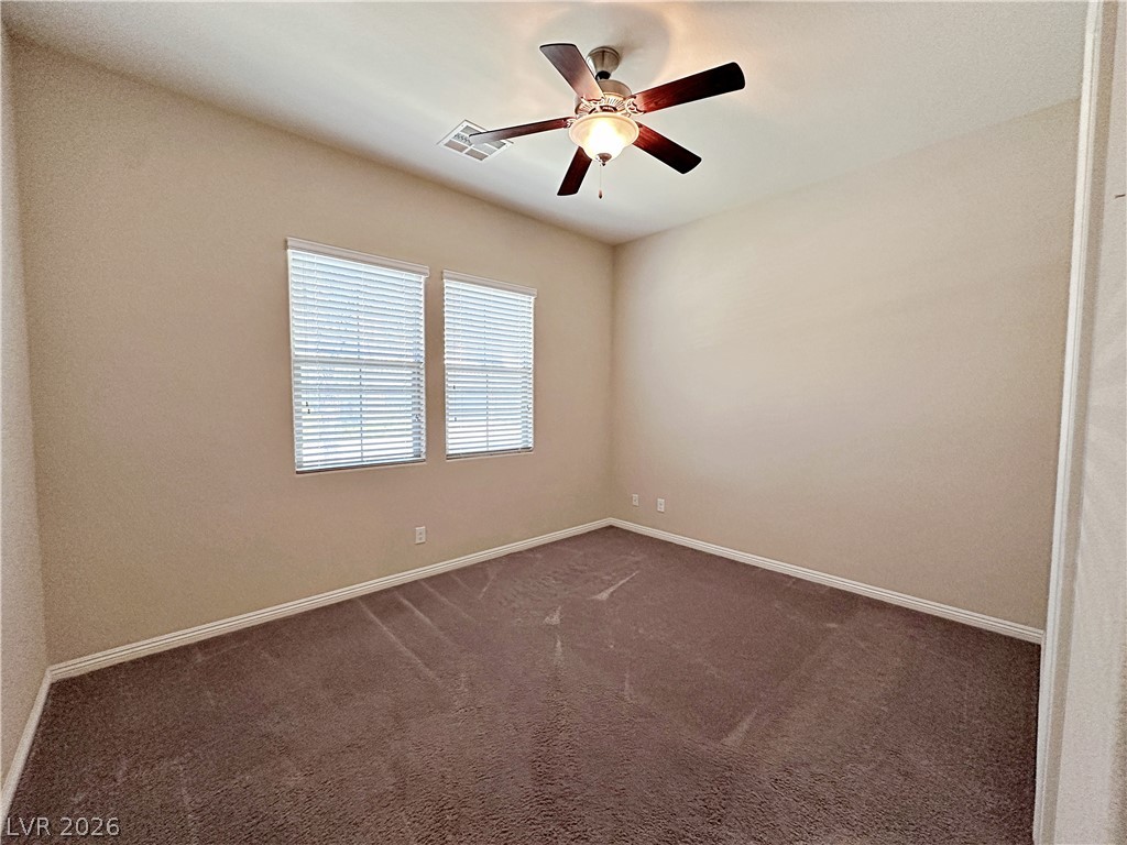 71 Newton Ridge Way Las Vegas, NV 89183 - Photo 19 of 40 A well-lit bedroom features plush carpeting and convenient ceiling fan for year-round comfort.