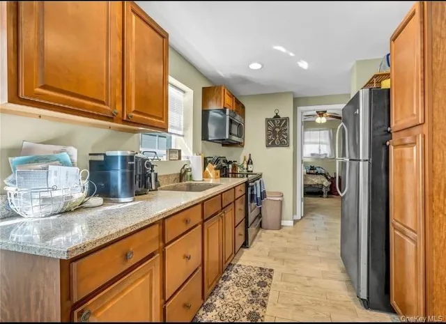 a kitchen with stainless steel appliances granite countertop a refrigerator and a sink