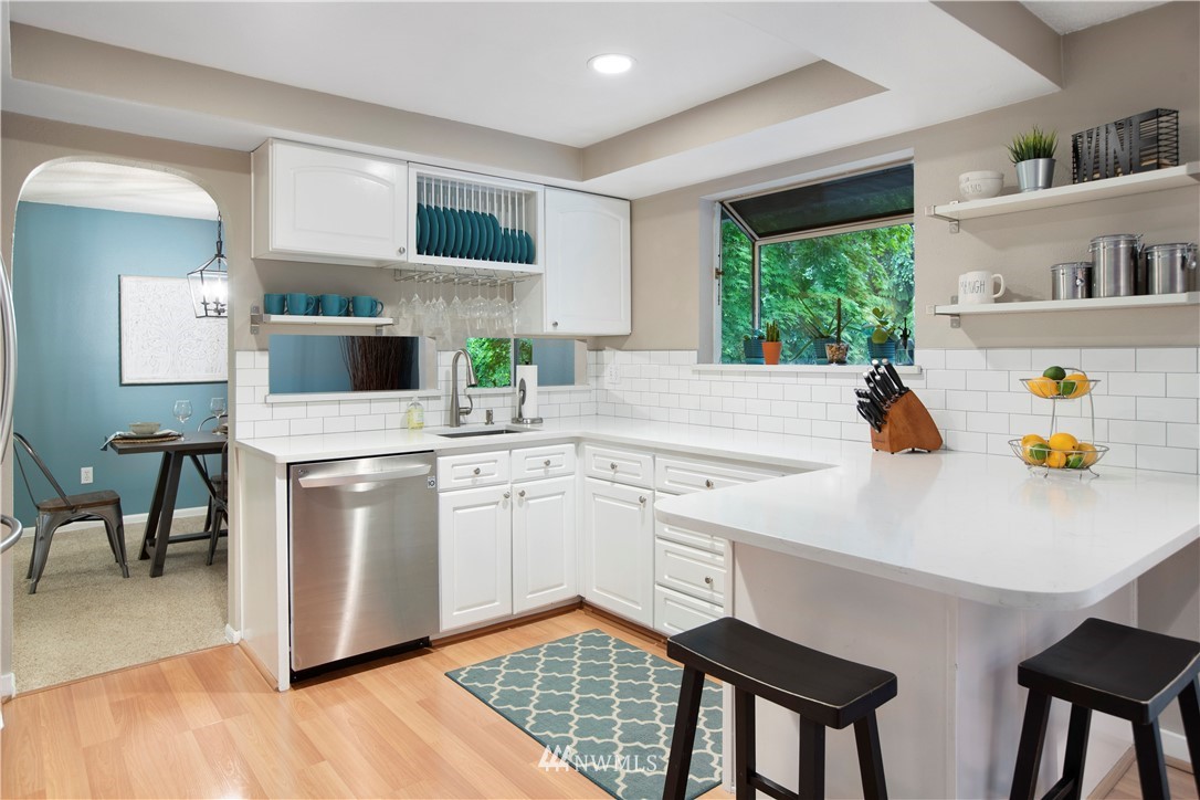 23625 48th Avenue Southeast Bothell, WA 98021 - Photo 13 of 40 a kitchen with stainless steel appliances a stove a sink cabinets and a window