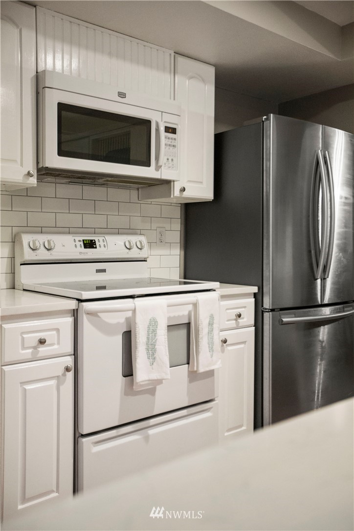 23625 48th Avenue Southeast Bothell, WA 98021 - Photo 15 of 40 a kitchen with stainless steel appliances white cabinets white stove a microwave and a refrigerator