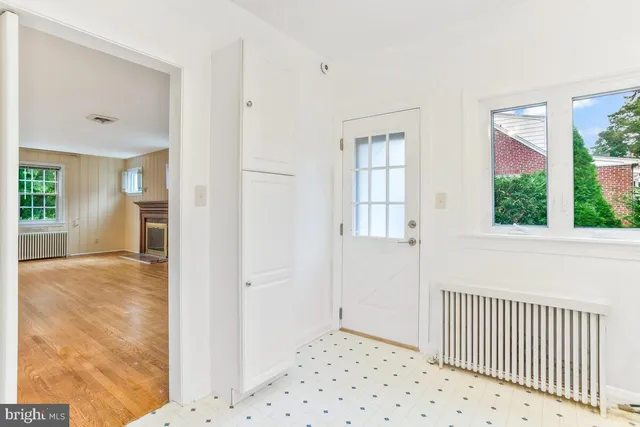 a view of a hallway with wooden floor and a bathroom