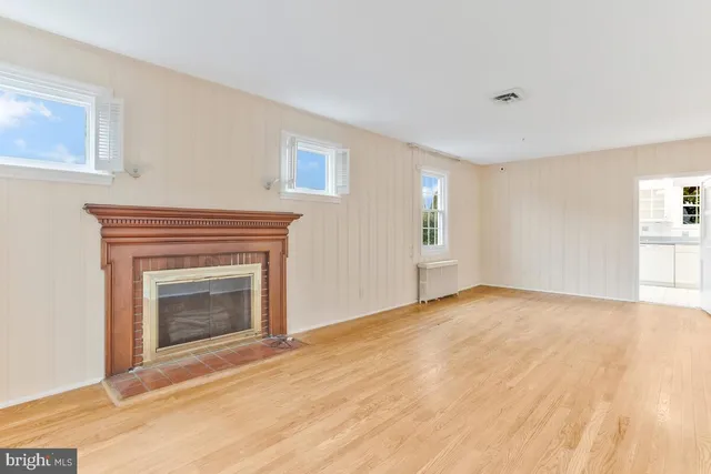 a view of empty room with wooden floor and fireplace