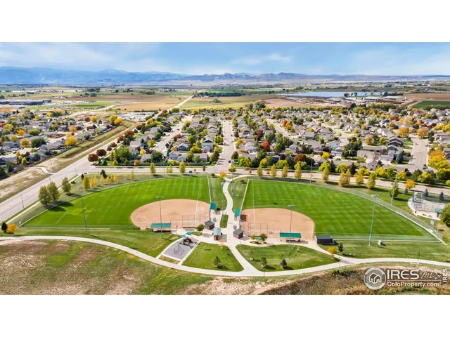 an aerial view of a tennis ground and a building in the back