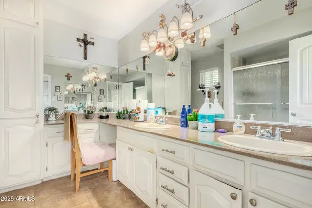 a spacious bathroom with a sink a large mirror and a chandelier