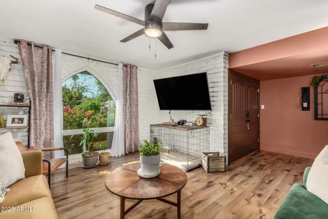 a living room with furniture a flat screen tv and a large window