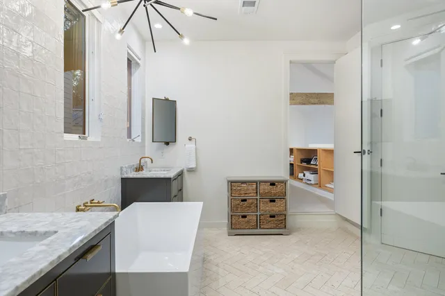 a bathroom with a granite countertop sink a mirror and bathtub