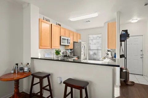 a kitchen with stainless steel appliances granite countertop a refrigerator and a stove top oven