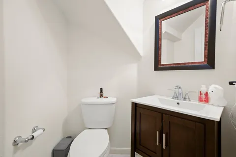 a bathroom with a toilet a sink and a large mirror