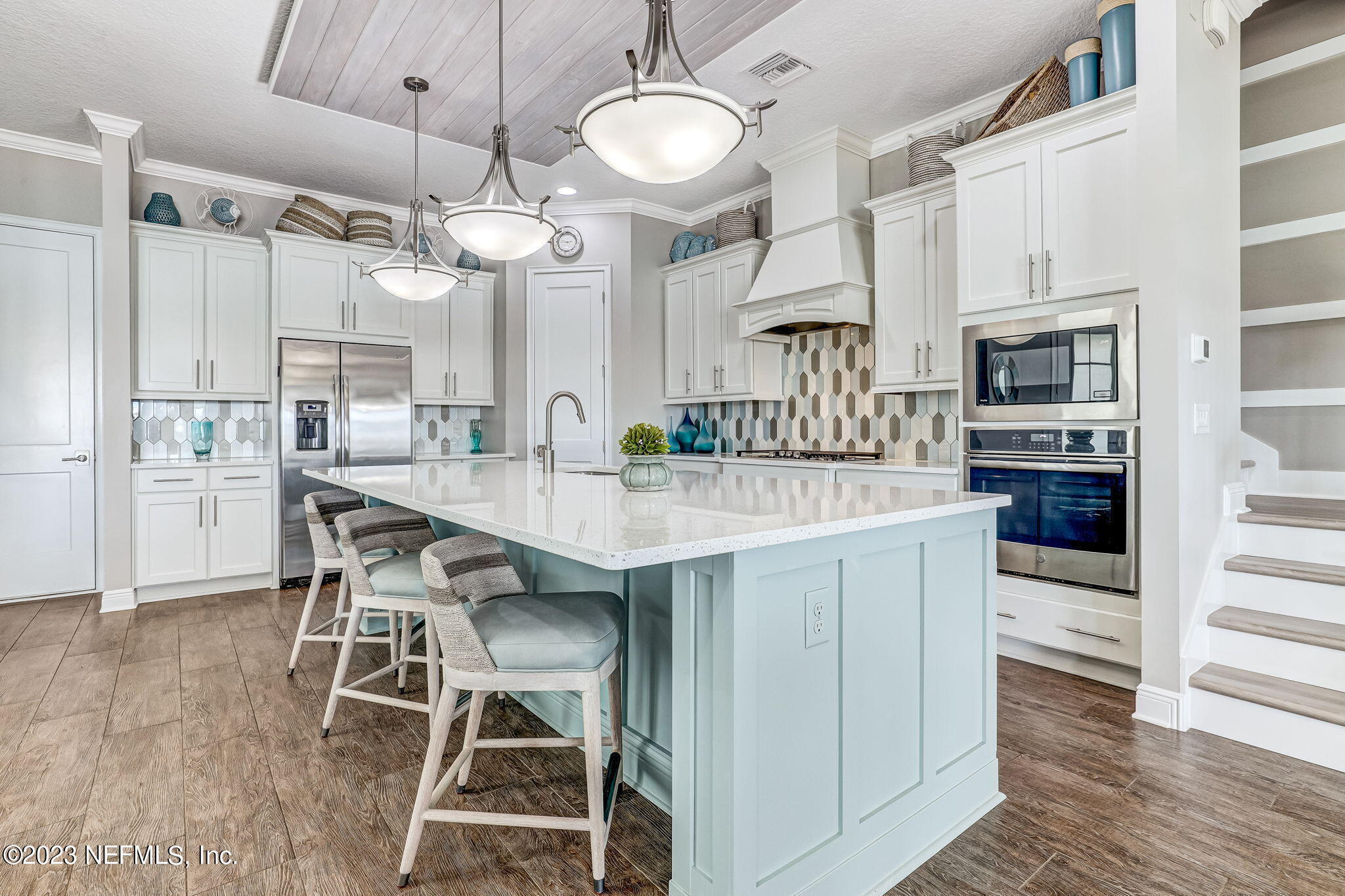 235 Rum Runner Way St. Johns, FL 32259 - Photo 24 of 108 a kitchen with stainless steel appliances kitchen island granite countertop a table chairs and a refrigerator