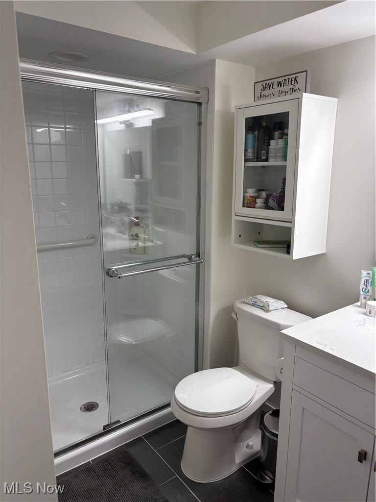 935 Canyon View Road, Unit 104 Northfield, OH 44067 - Photo 27 of 46 Bathroom featuring toilet, vanity, tile patterned floors, and a shower stall