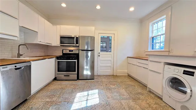 a kitchen with stainless steel appliances granite countertop a refrigerator and a stove top oven