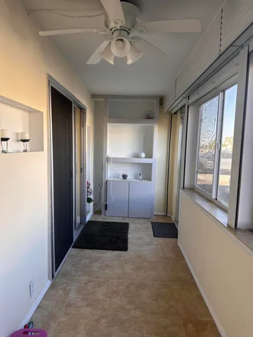 a view of a hallway with a livingroom and a chandelier fan