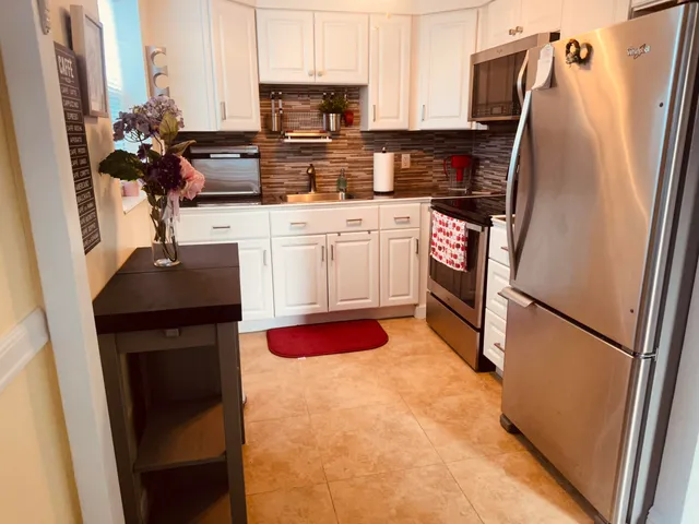 a kitchen with stainless steel appliances a stove refrigerator and a sink