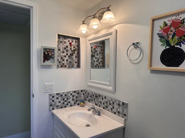 a bathroom with a sink mirror and vanity