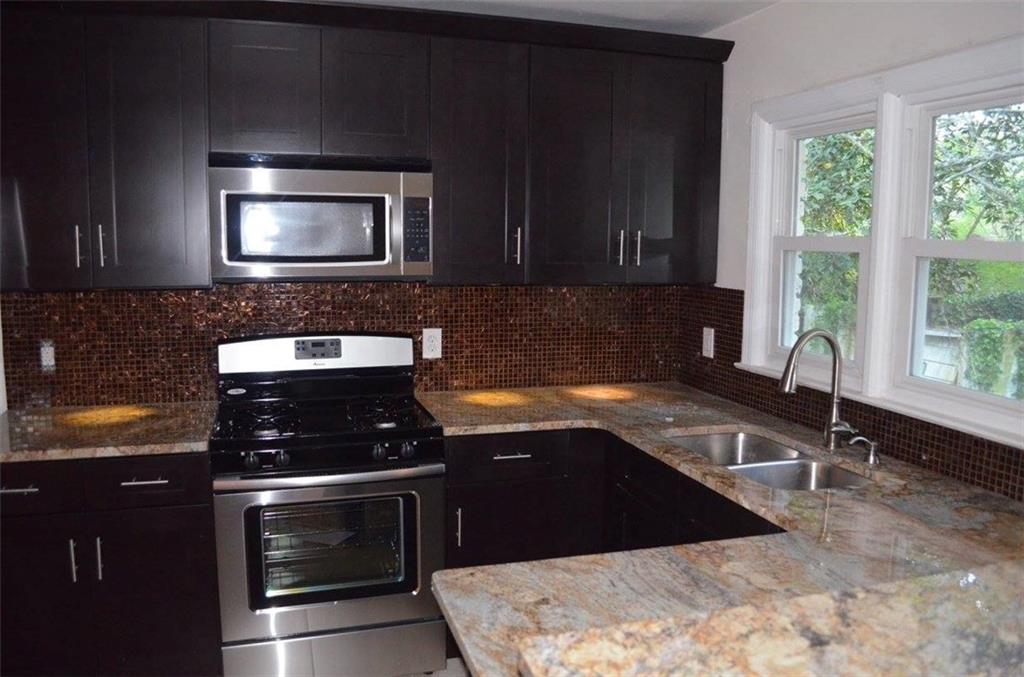 1329 Westridge Road Southwest Atlanta, GA 30311 - Photo 31 of 54 a kitchen with granite countertop a stove and a sink