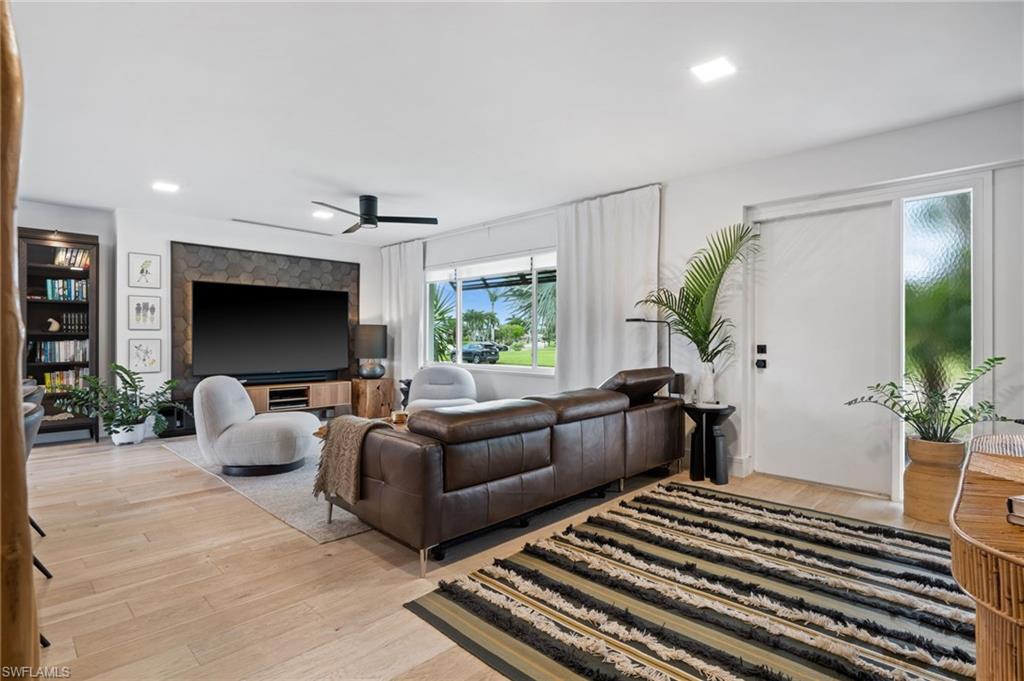304 Nason Lane Naples, FL 34112 - Photo 13 of 43 a living room with furniture a flat screen tv and a potted plant
