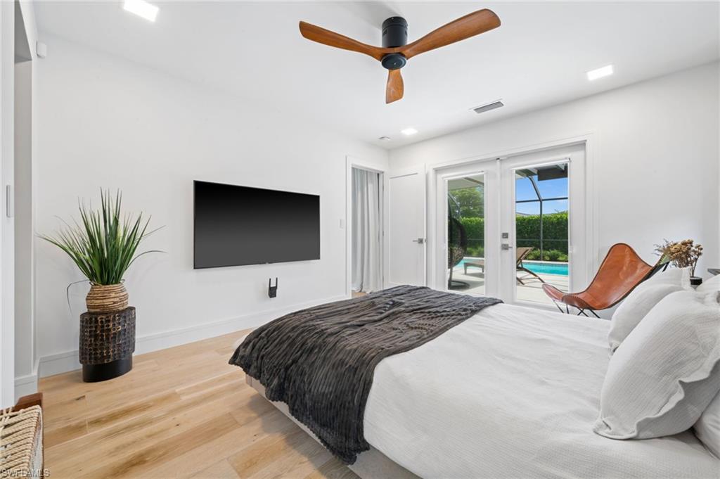 304 Nason Lane Naples, FL 34112 - Photo 19 of 43 a bedroom with a bed and a flat screen tv