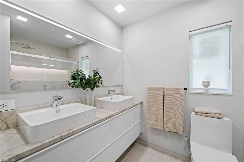 304 Nason Lane Naples, FL 34112 - Photo 26 of 43 a bathroom with a sink and a mirror