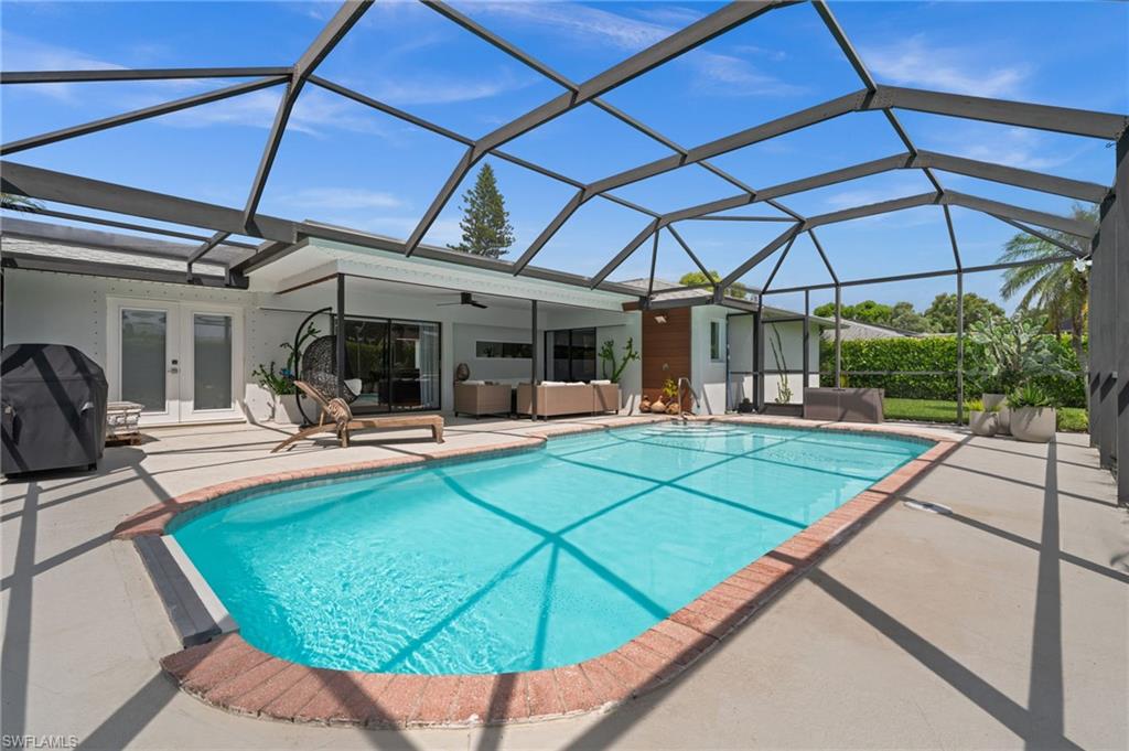 304 Nason Lane Naples, FL 34112 - Photo 35 of 43 a view of a backyard with table and chairs under an umbrella
