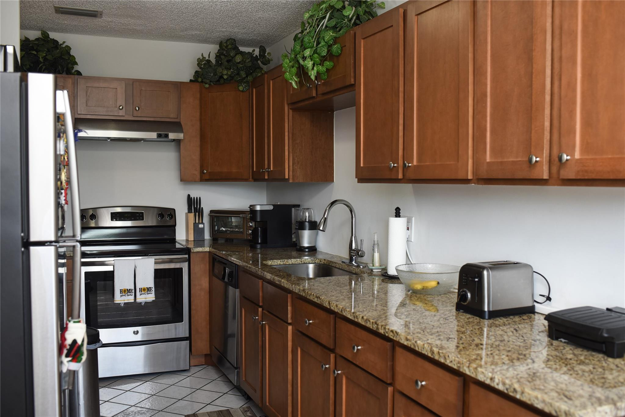 20932 Sedgewick Drive, Unit 400 Boca Raton, FL 33433 - Photo 11 of 34 a kitchen with granite countertop stainless steel appliances a stove a sink dishwasher and cabinets with wooden floor