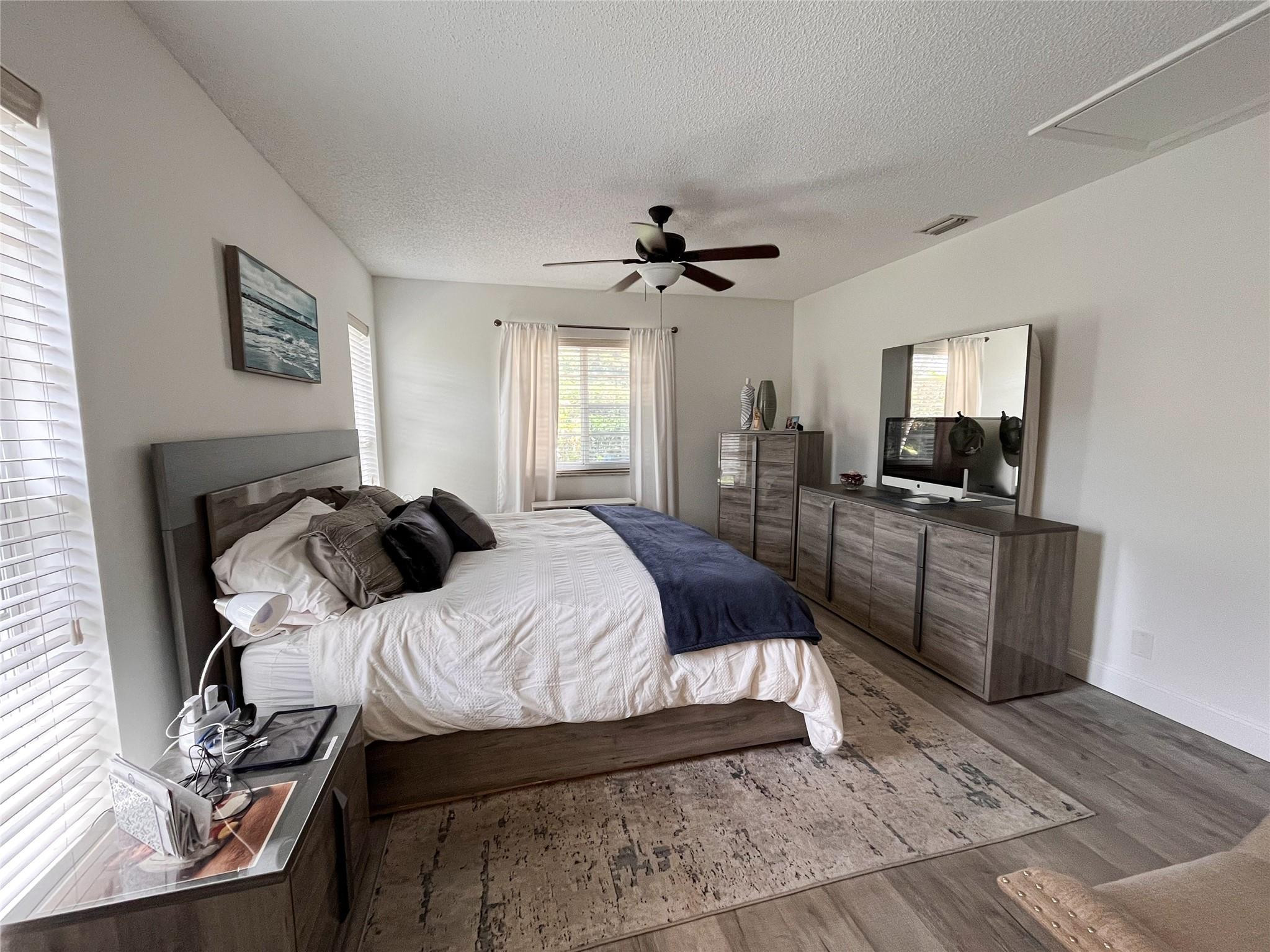 20932 Sedgewick Drive, Unit 400 Boca Raton, FL 33433 - Photo 16 of 34 a large bedroom with a bed and a television in it