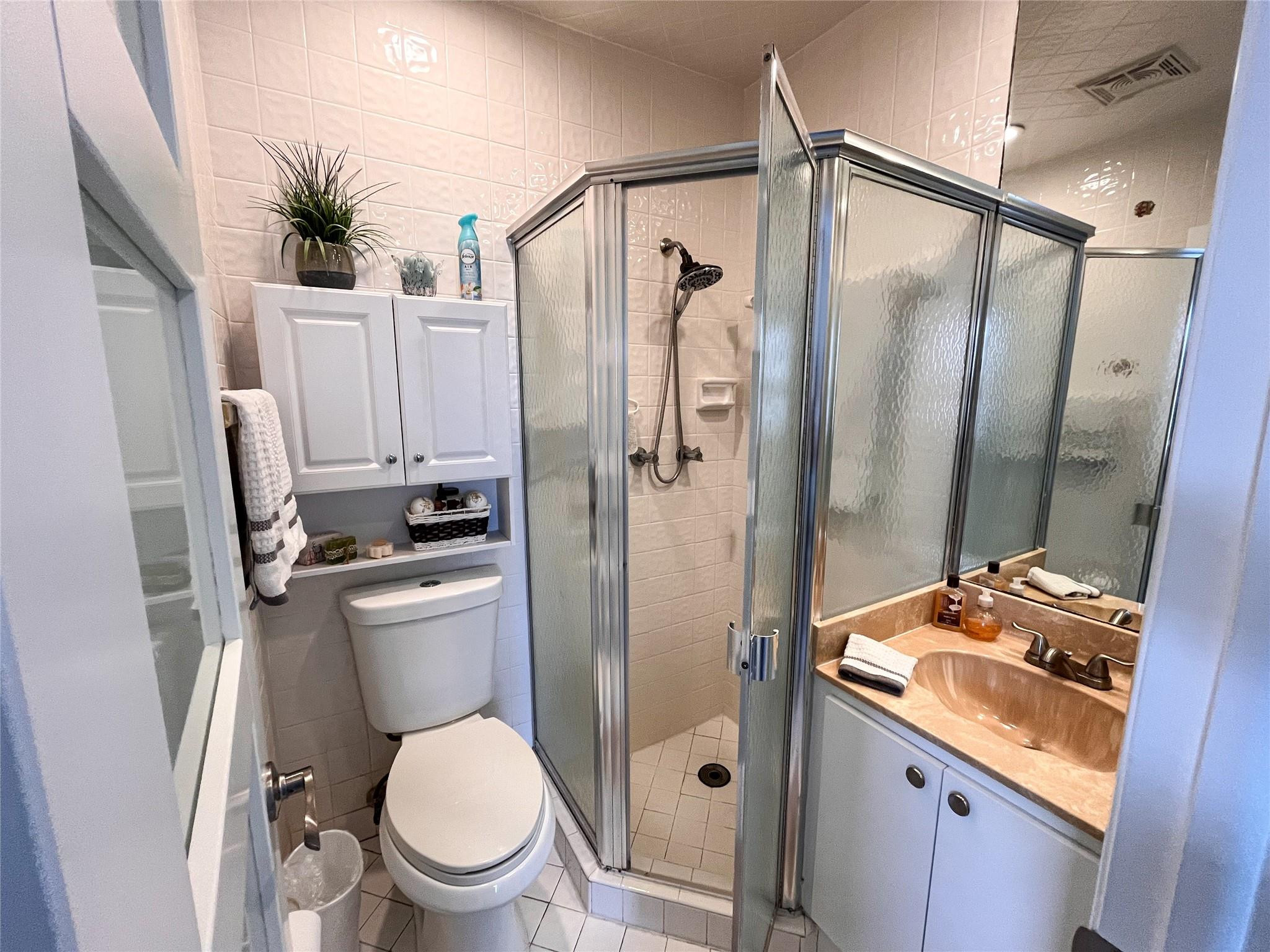 20932 Sedgewick Drive, Unit 400 Boca Raton, FL 33433 - Photo 25 of 34 a bathroom with a granite countertop sink toilet and shower