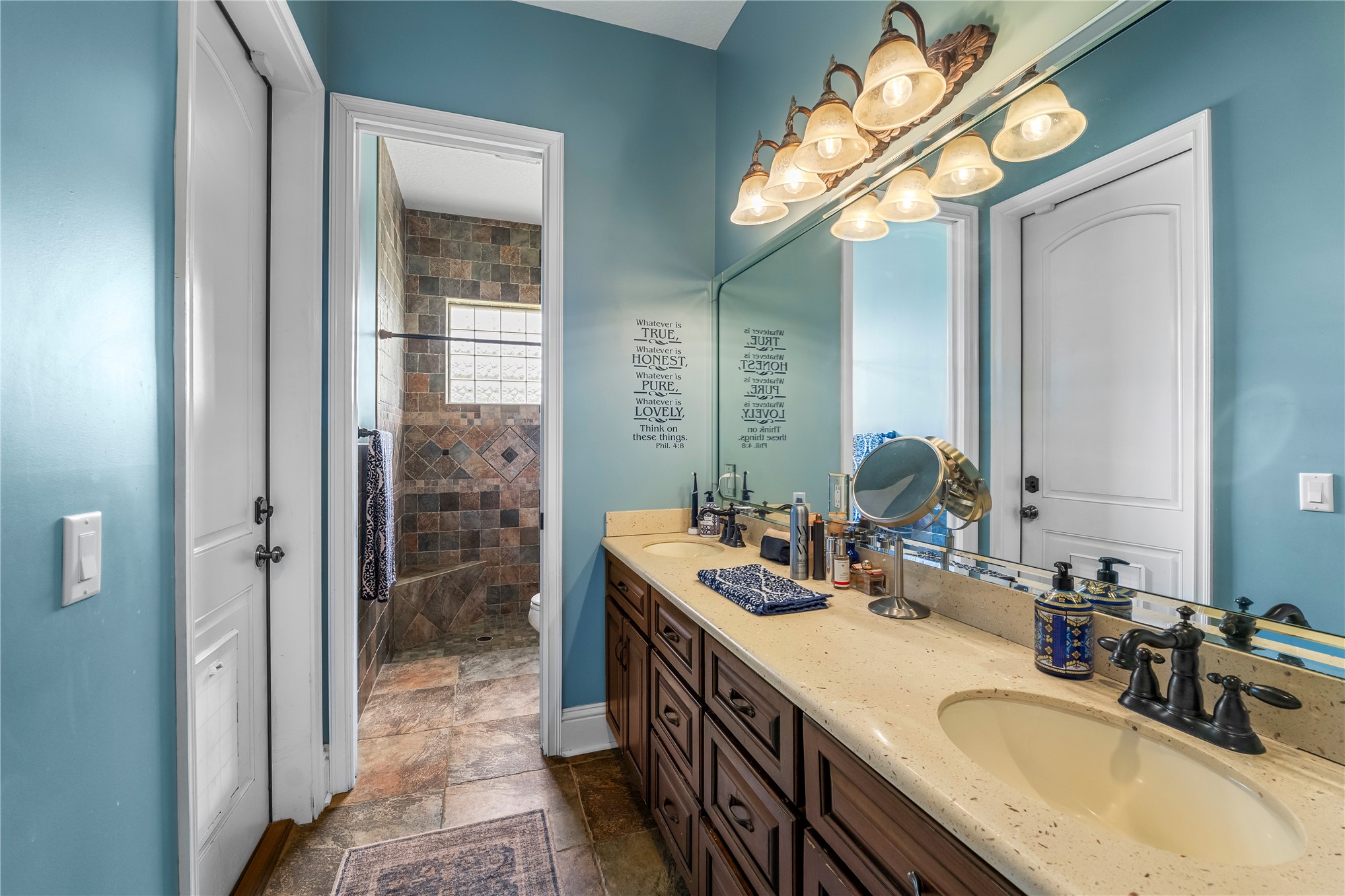 27247 Hallman Road Hilliard, FL 32046 - Photo 40 of 59 a bathroom with a granite countertop sink a mirror a vanity and shower