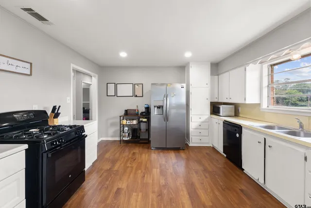 a kitchen with granite countertop a sink cabinets and window