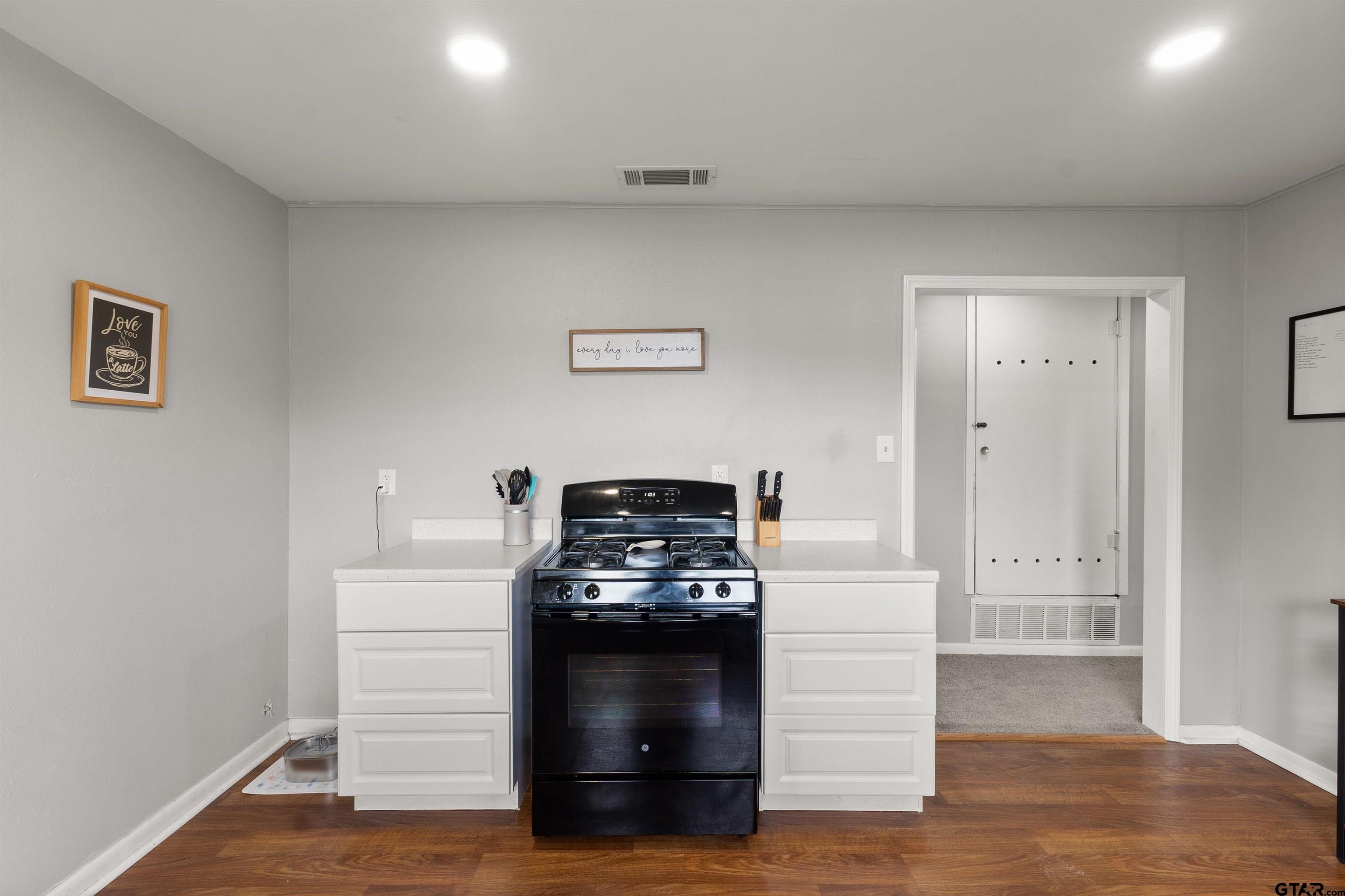 910 West Vance Street Tyler, TX 75702 - Photo 15 of 26 a kitchen with a stove and a wooden floor