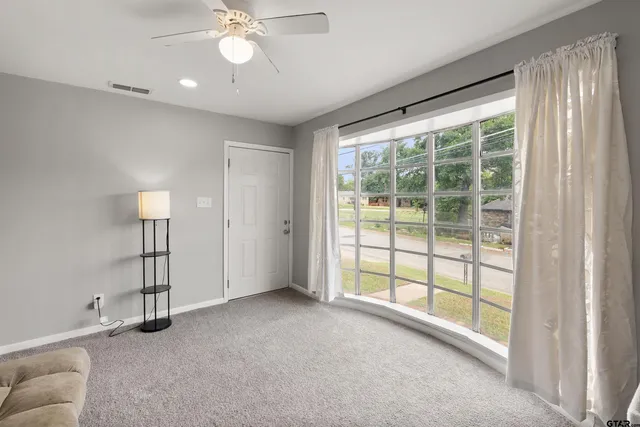 a view of a livingroom with a ceiling fan and window