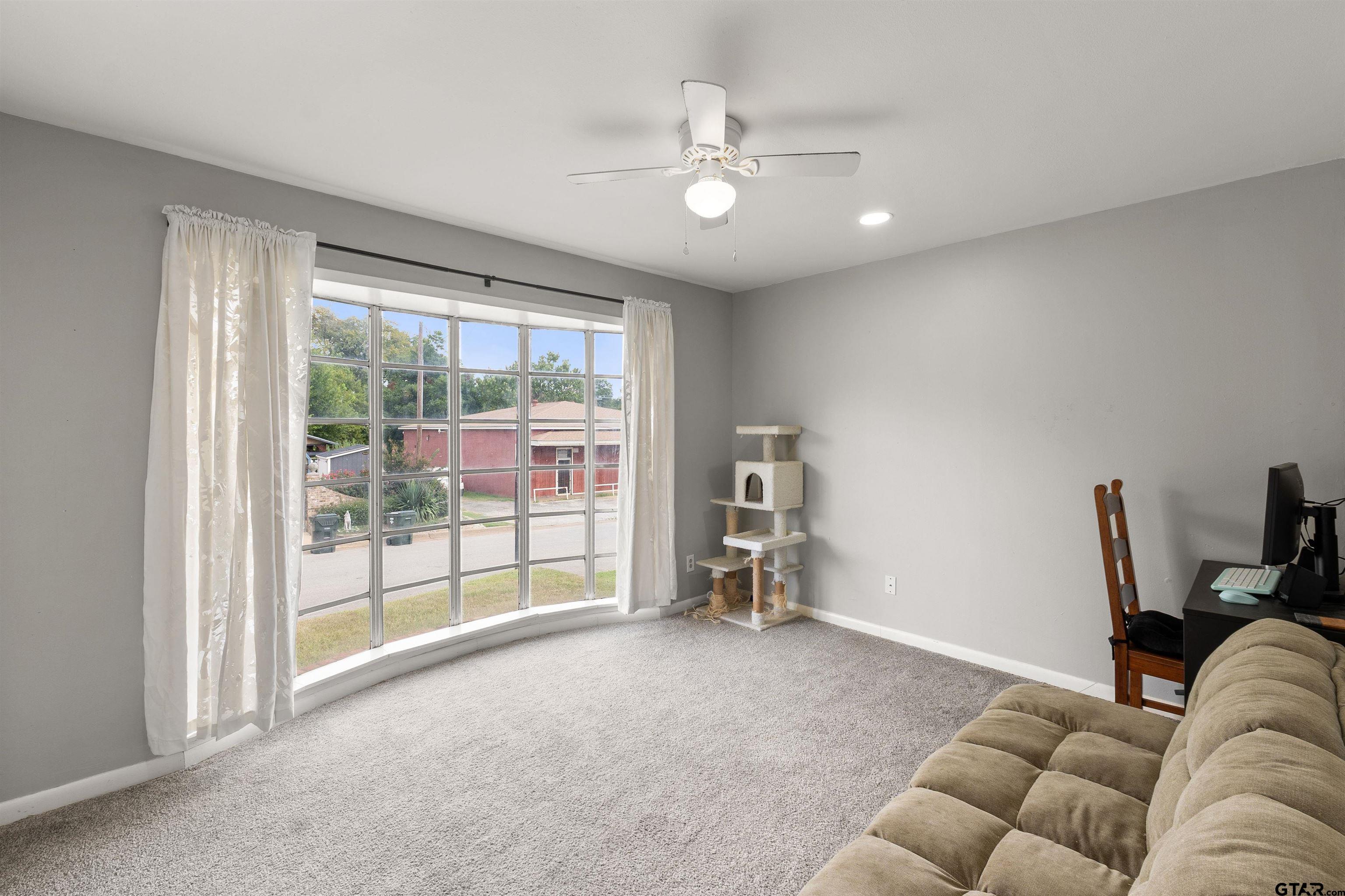 910 West Vance Street Tyler, TX 75702 - Photo 3 of 26 a living room with furniture and a floor to ceiling window