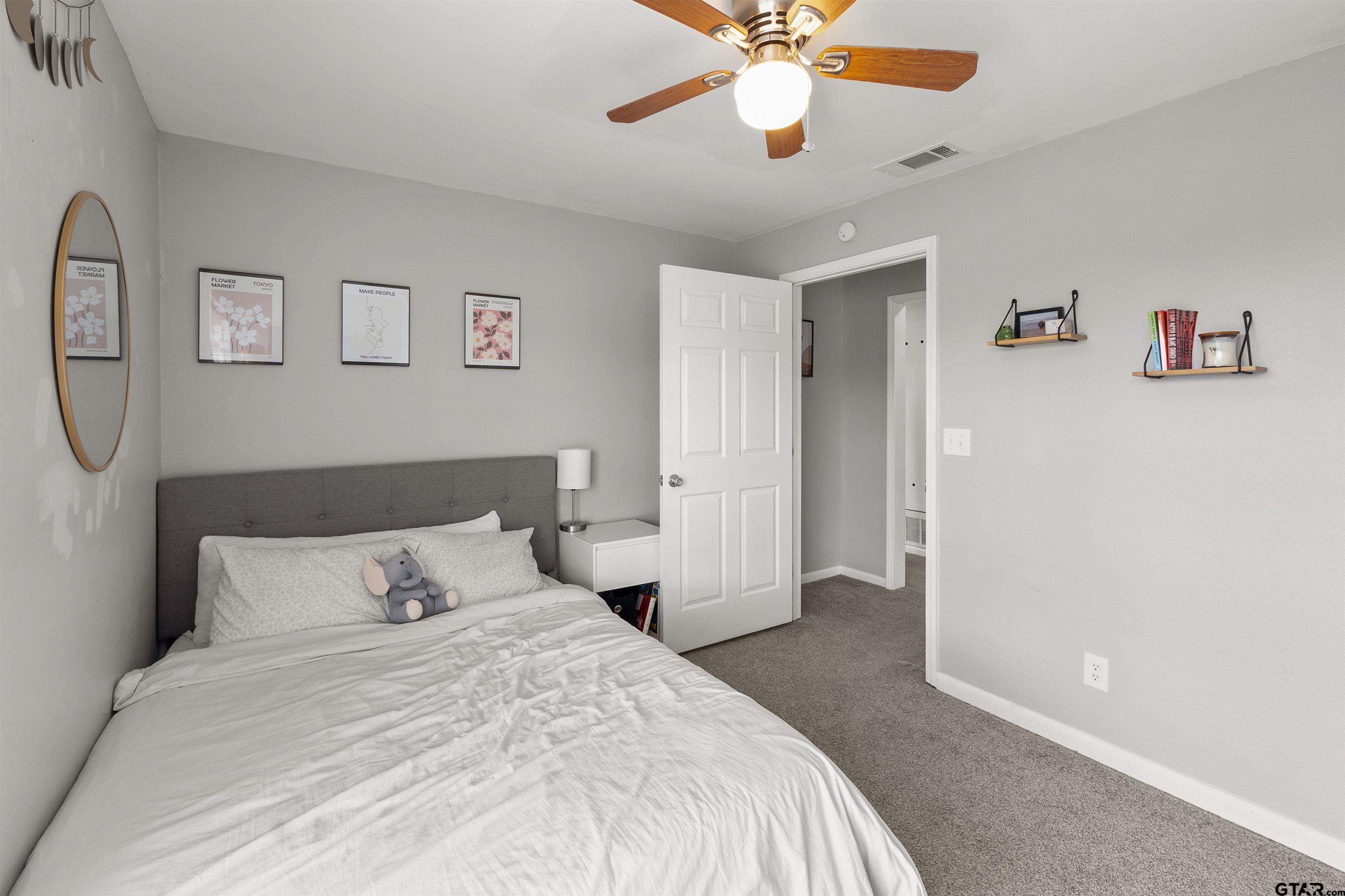 910 West Vance Street Tyler, TX 75702 - Photo 5 of 26 a bedroom with a bed and a chandelier