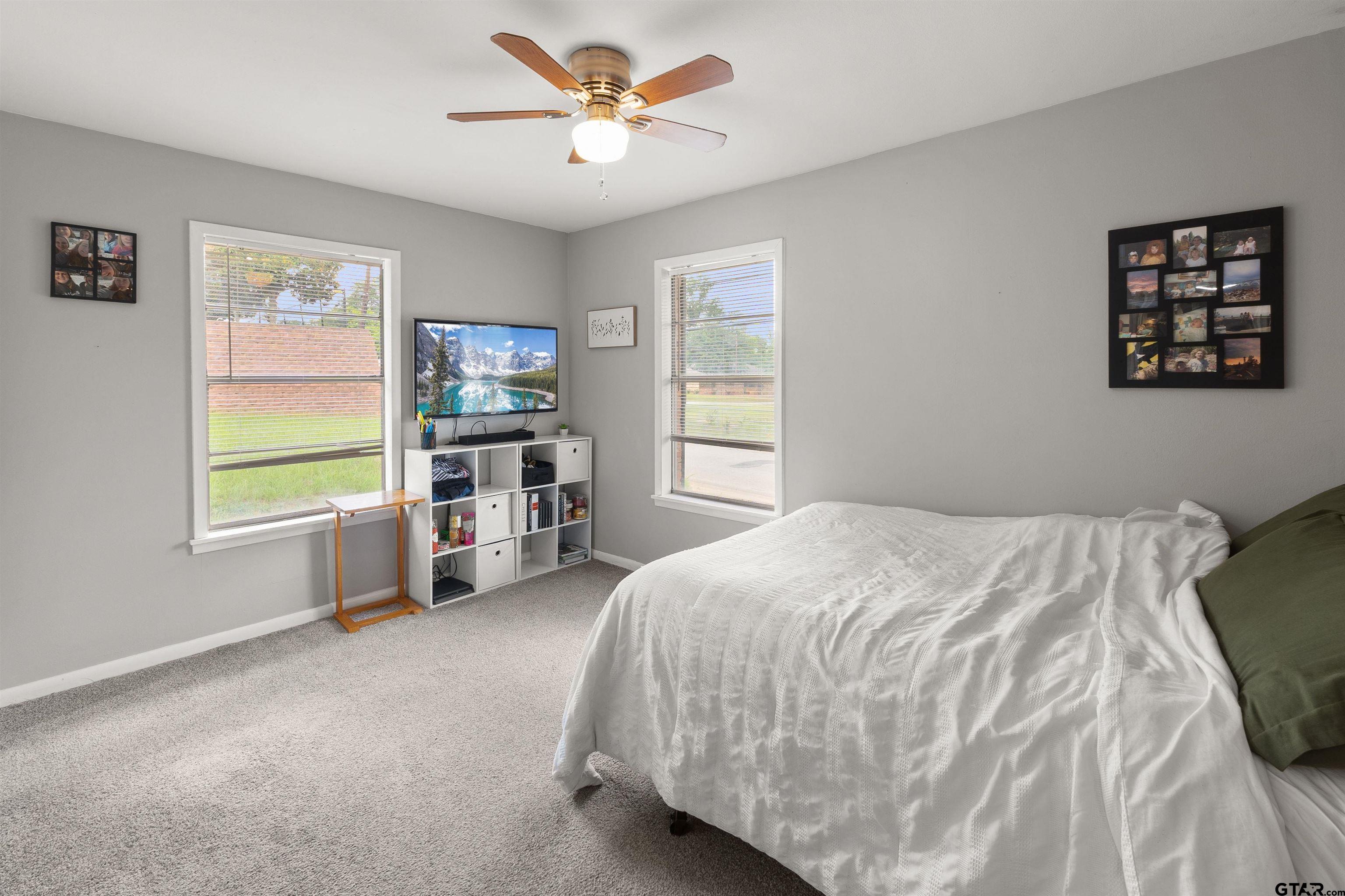 910 West Vance Street Tyler, TX 75702 - Photo 6 of 26 a bedroom with a bed next to a window and a chandelier
