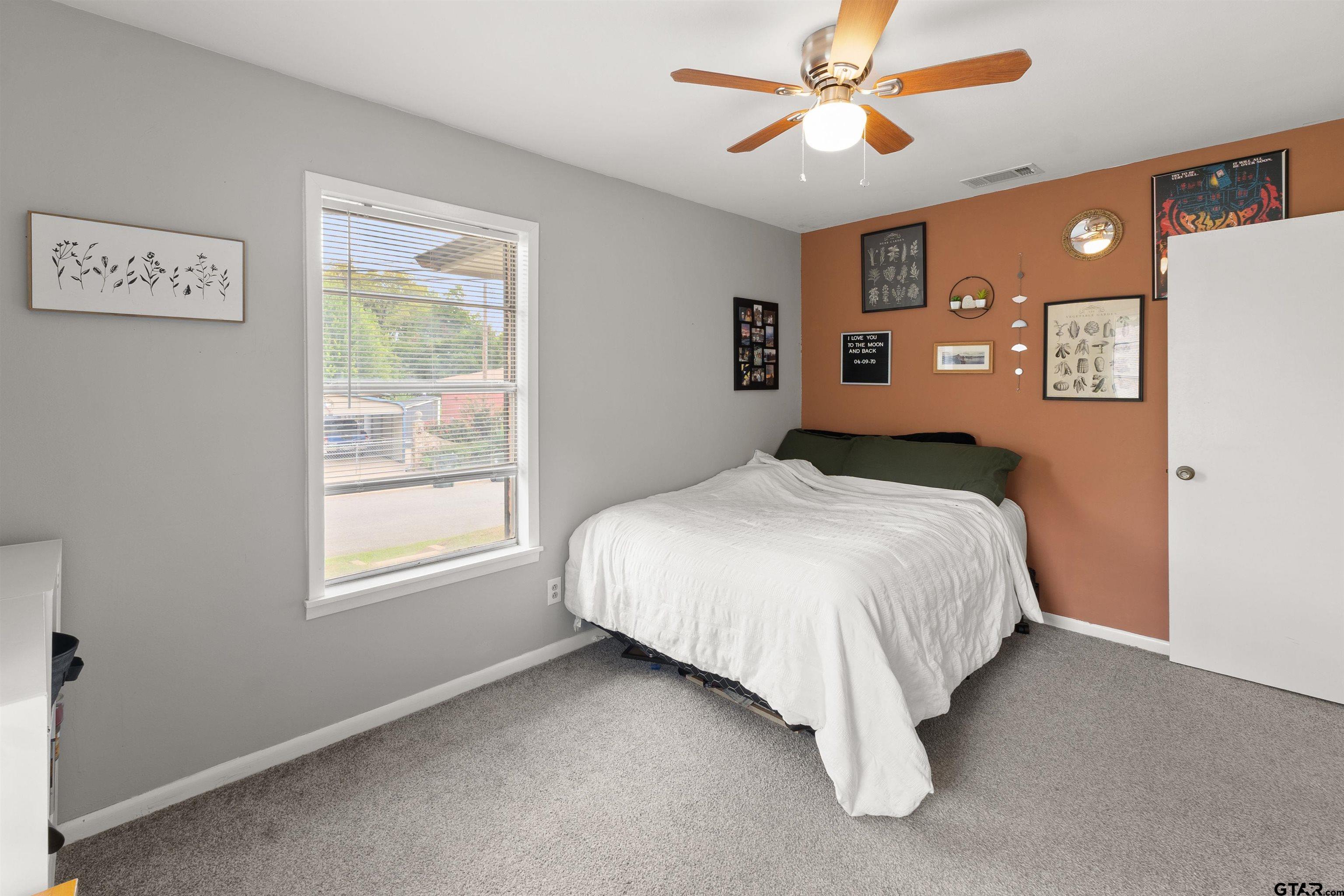 910 West Vance Street Tyler, TX 75702 - Photo 7 of 26 a bed sitting in a bedroom next to a window