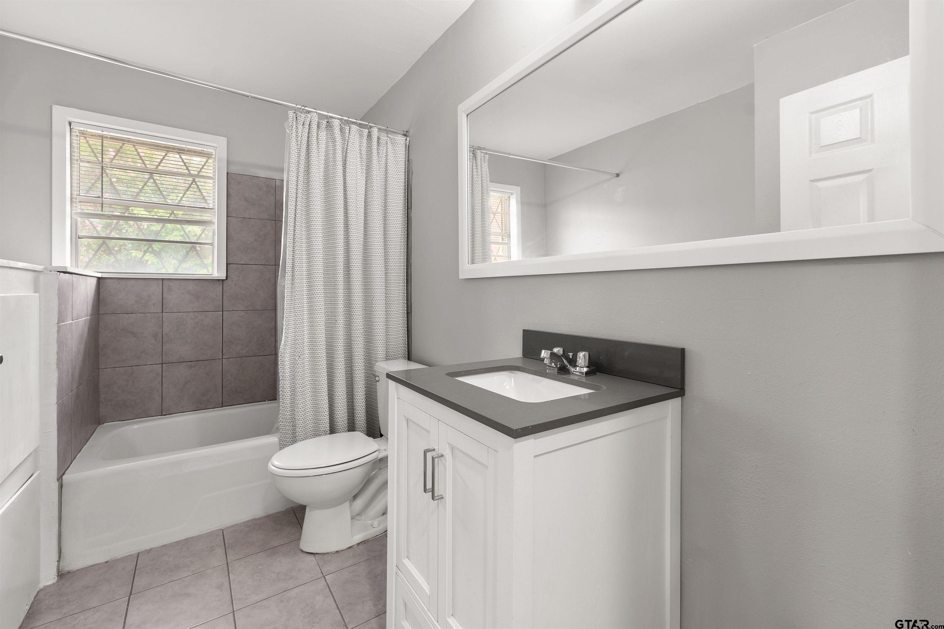 910 West Vance Street Tyler, TX 75702 - Photo 8 of 26 a bathroom with a sink toilet and shower