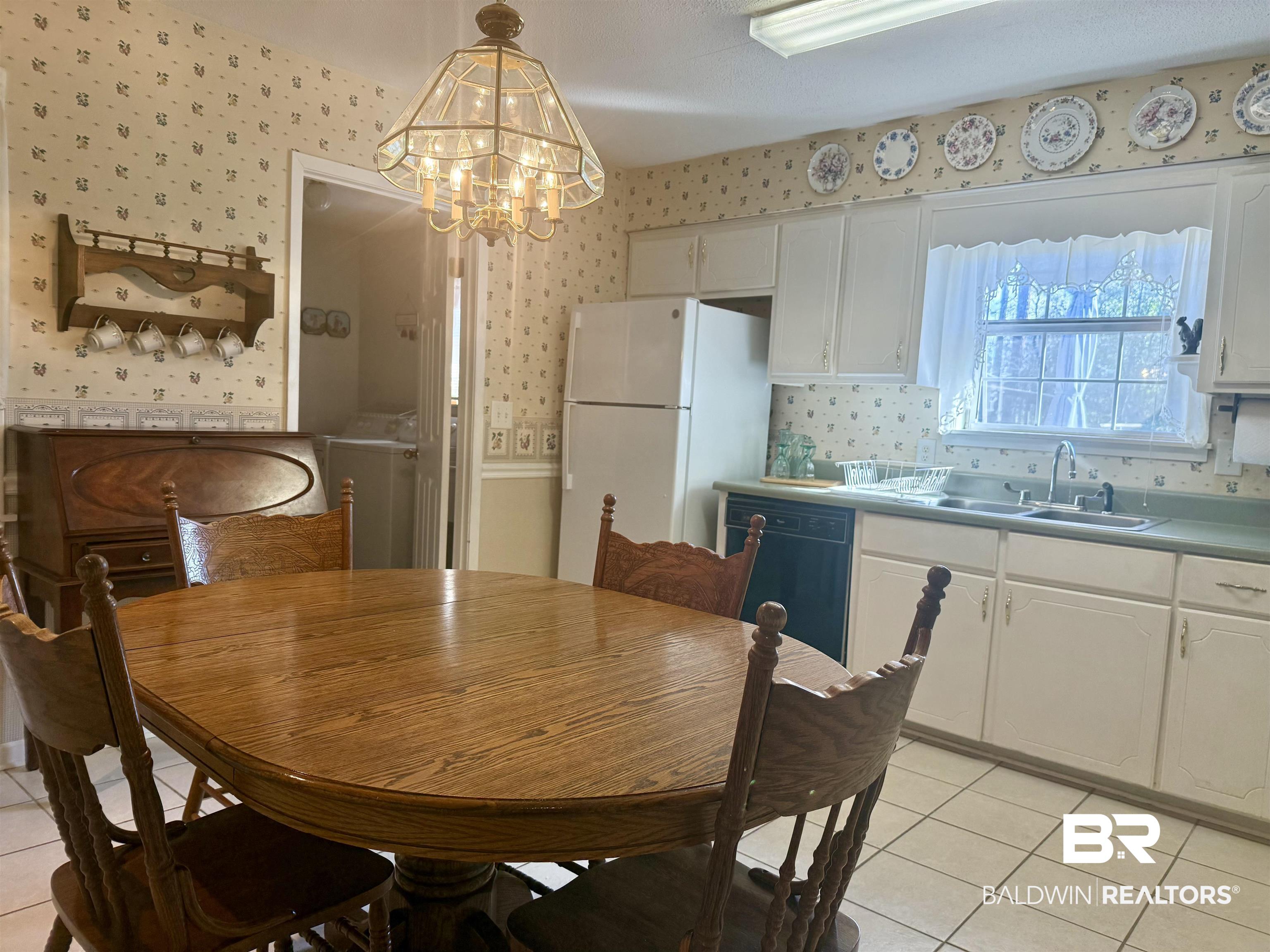 215 Young Street Brewton, AL 36426 - Photo 5 of 25 Dining area featuring light tile patterned floors, a chandelier, and washer / clothes dryer