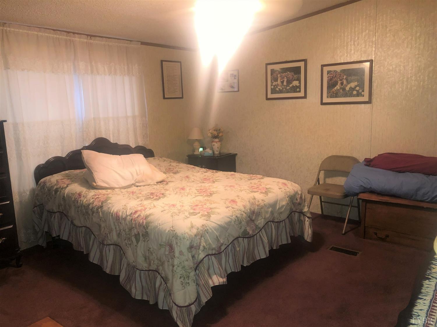 55 Carwile Road Rustburg, VA 24588 - Photo 7 of 10 a bedroom with a bed and chair