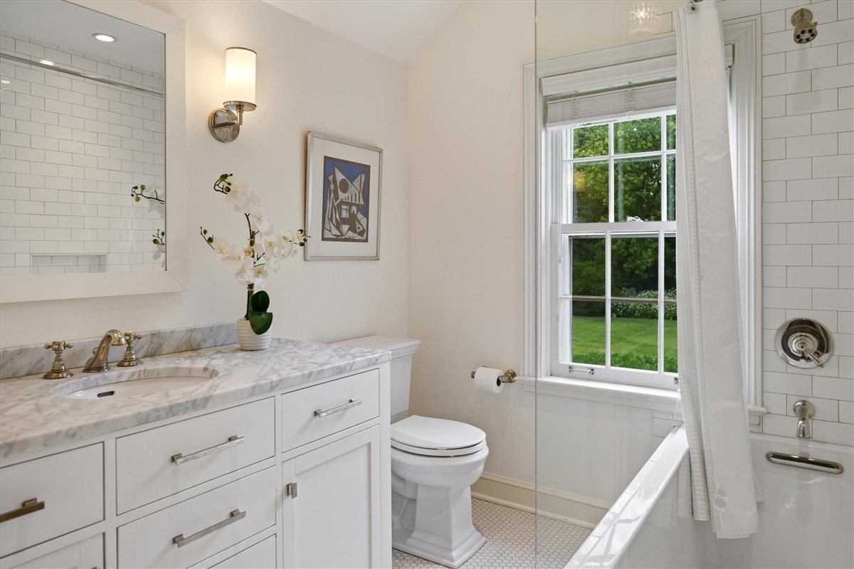 62 Woodley Road Winnetka, IL 60093 - Photo 32 of 43 a bathroom with a granite countertop sink a large mirror a toilet and a shower