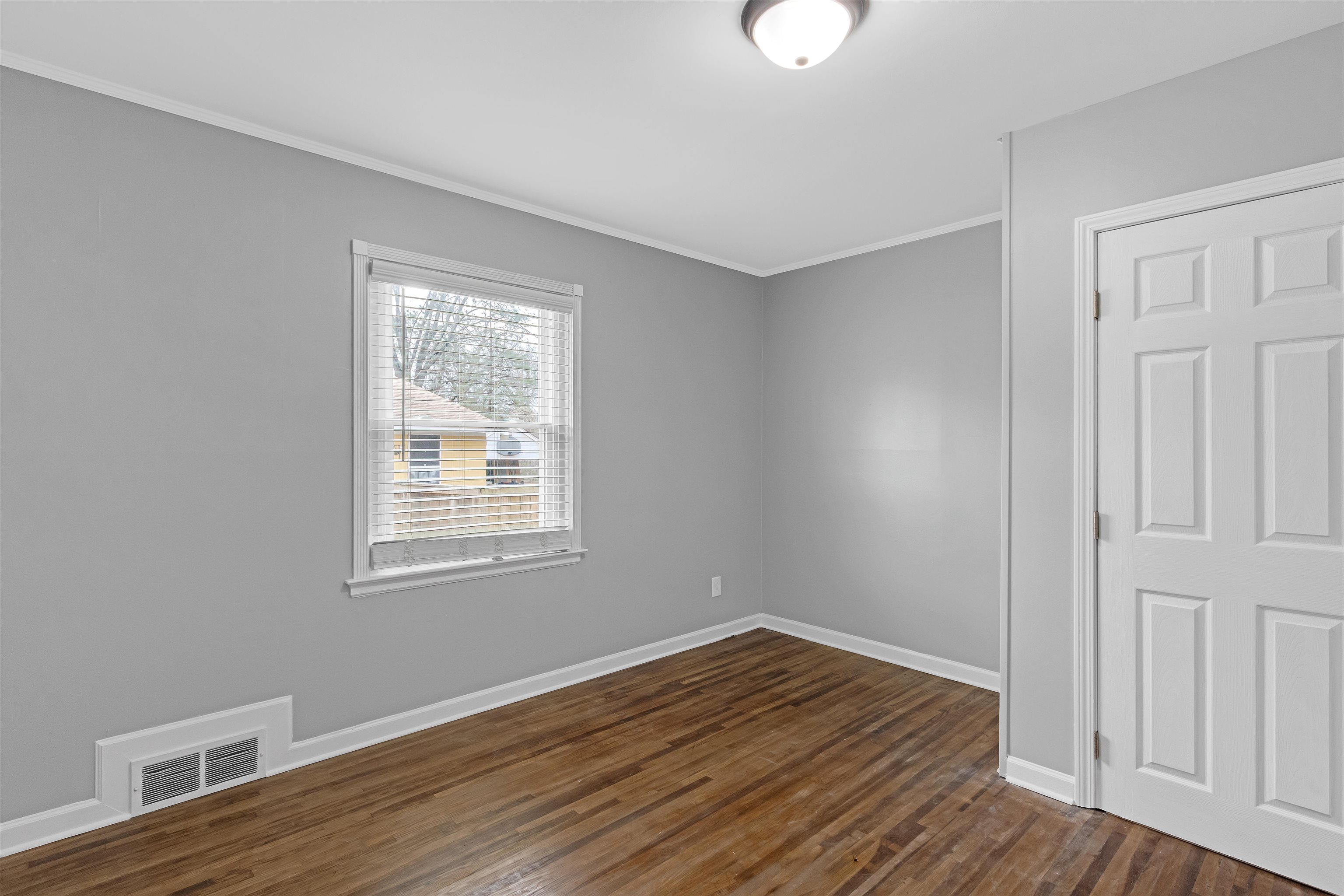 1303 Inman Road Memphis, TN 38111 - Photo 4 of 12 Unfurnished room featuring visible vents, crown molding, baseboards, and dark wood-style flooring